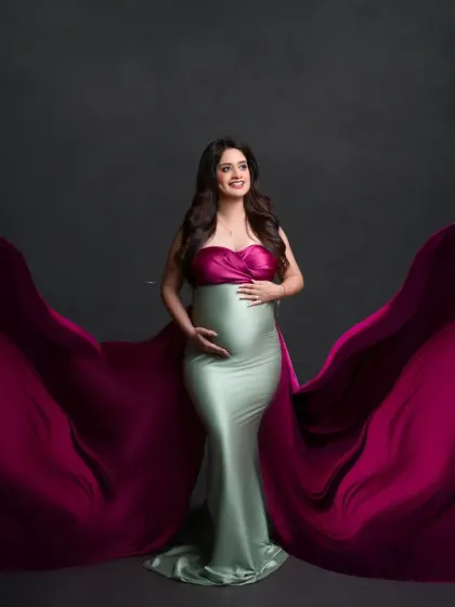 A unique and fashionable choice. This dual-toned gown, with a magenta top and mint green bottom, features dramatic flowing fabric for a bold and artistic statement.
