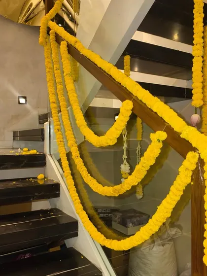 Staircase railing wrapped in bright yellow marigold garlands for a traditional Diwali home decor look.