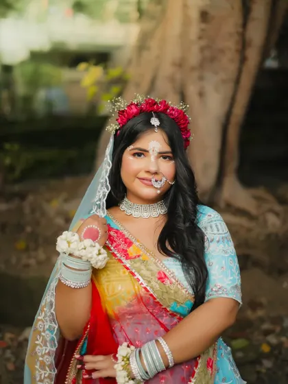 A solo portrait of Radha, showcasing her soft makeup and floral jewelry.
