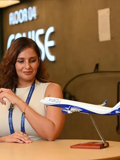 A branding portrait for an Indigo staff member. Using the model airplane as a prop reinforces the connection to the aviation industry in a creative way.