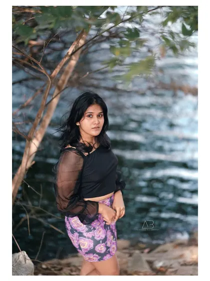 An outdoor portrait by the water. The natural setting and the soft breeze in her hair give this shot a relaxed and serene feeling.