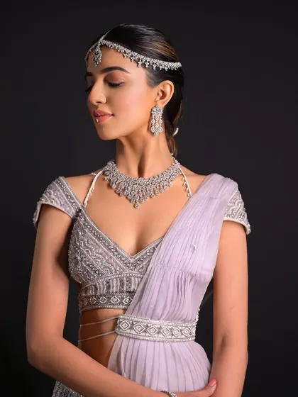 A beautiful profile shot showing how the sleek front of the hairstyle complements the intricate jewelry. This is a key part of creating a cohesive bridal look.