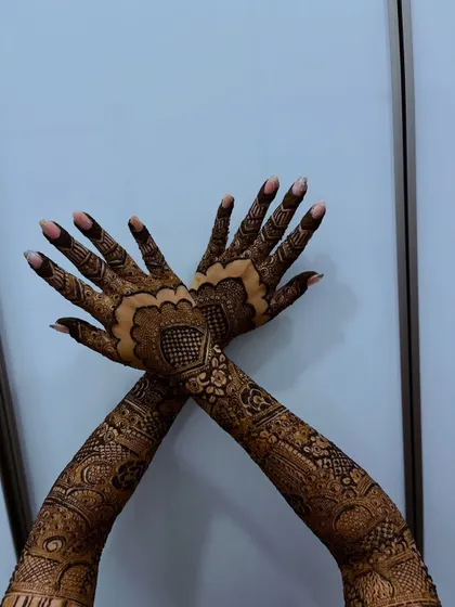 A crossed-hands pose showing the symmetry and detail of the bridal henna.