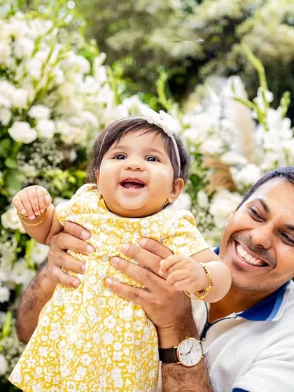 A joyful family portrait in black and white. Their bright smiles show the happiness of celebrating their daughter's milestone together.