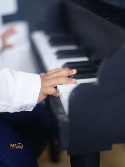 A close-up shot of his tiny hand on the piano keys. It's these little details that make the memory complete.