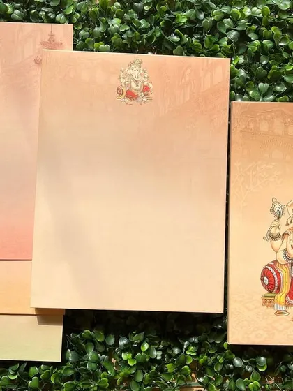 An elegant invitation set with a beautiful illustration of Lord Ganesha. The inserts feature a soft color gradient, adding a modern touch to a traditional design.