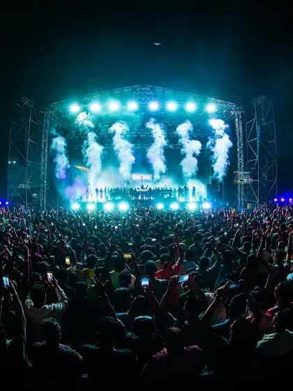 A fish-eye lens captures the immense scale of the crowd and stage for Armin van Buuren, with smoke cannons firing in unison.