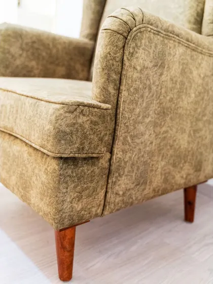 A duplicate of image 218, focusing on the details of the upholstery and the tapered wooden legs of the wingback chair.