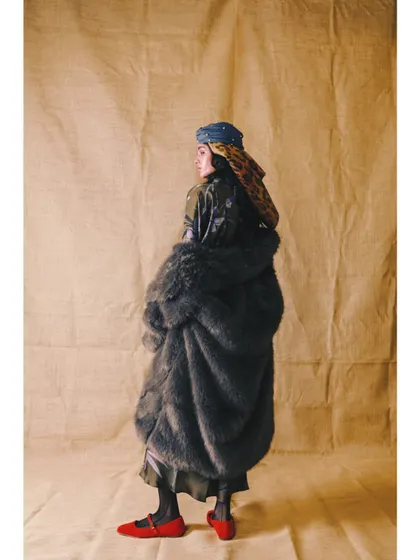A more subdued look from 'Neo-Boheme', featuring a voluminous fur-textured coat and layered headscarves. The pop of red from the shoes adds a surprising, stylish detail.