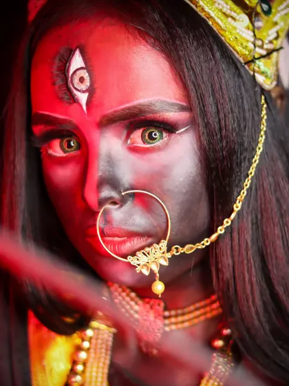 A striking close-up of a goddess look, with a third eye and intense red lighting.