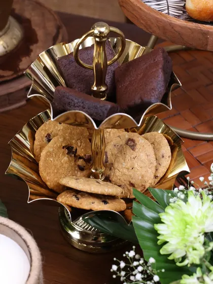 Our two-tiered gold stand with scalloped, flower-like bowls. It’s a beautiful and functional piece for serving cookies, brownies, or other small bites during a high tea or festive gathering.