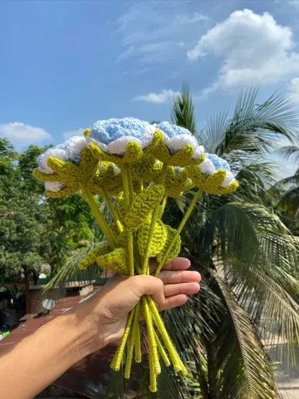 A side view of the light blue rose bouquet, showing the detailed green stems and leaves.