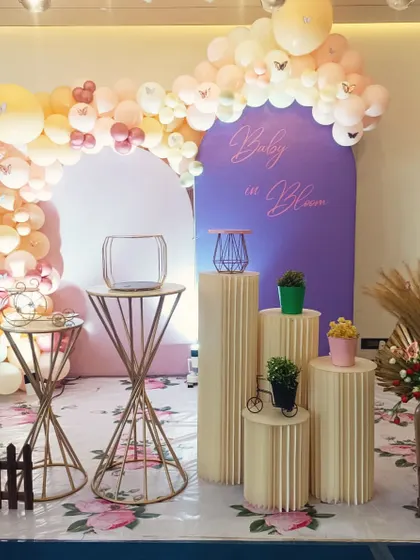 A beautiful 'Baby in Bloom' shower theme with a butterfly balloon arch and boho elements like pampas grass.