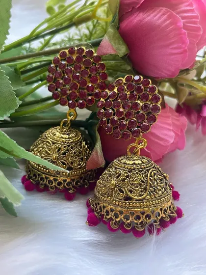 A close-up of the gold-oxidised dome and the rich pink velvet beads of the party-wear jhumkas.