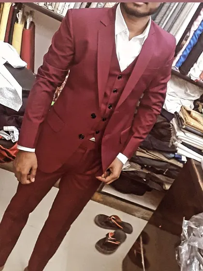 A client trying on his new maroon three-piece suit in my shop. I work with you to ensure every detail is perfect before you take it home.