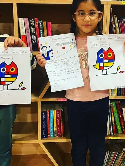 Proud students showing their Piet Mondrian inspired artwork. Combining art with learning makes the lessons more memorable and engaging.