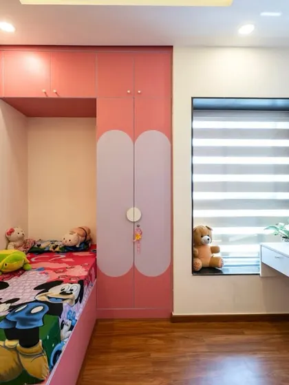 A closer look at one of the bed nooks, featuring a custom-built bed with integrated storage and a playful, modern wardrobe design.