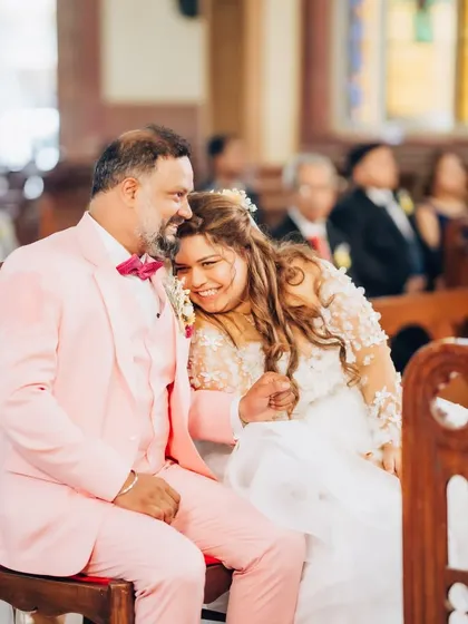 A sweet, tender moment in the church pew. The bride's joy is palpable as she leans on her new husband.
