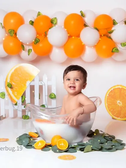 This baby is having a wonderful time splashing in the tub during our summery orange-themed bath shoot.