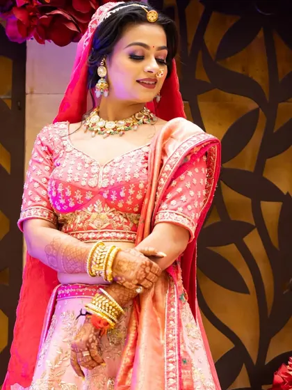 An elegant portrait of the bride in her pink and peach lehenga, looking radiant.