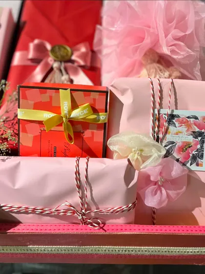 A close-up of the red and pink themed gift wrapping, showing the different textures of paper, ribbons, and embellishments.