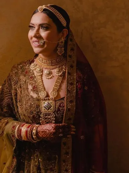 A bride in her full wedding attire, with her hair in a secure and elegant floral bun under her dupatta. This hairstyle is designed to be both beautiful and practical.