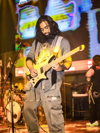 Our guitarist in the zone, delivering a complex solo. Our live shows are packed with moments of incredible musicianship.
