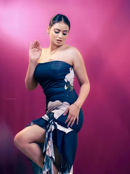 A high-fashion studio shot with dramatic pink lighting. The pose is dynamic and powerful, perfect for an editorial or fashion-forward portfolio.