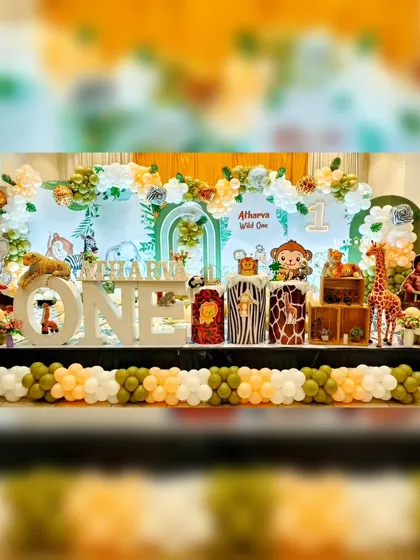 A large-scale jungle safari theme on a full stage, with a mix of cartoon animals and floral balloon arrangements.