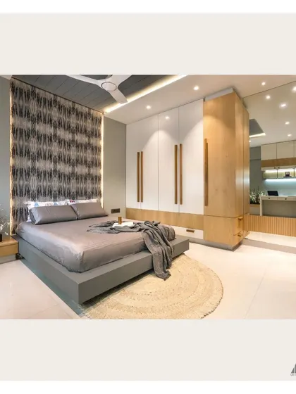 A wide view of the modern grey bedroom. The design features a floating platform bed, a full-height wardrobe with wood accents, and a large mirror that enhances the sense of space.