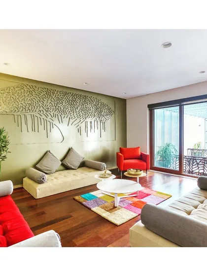 In this family living space, we commissioned a custom "Tree of Life" wall art piece to serve as the room's anchor. The design combines earthy tones with pops of color in the furnishings to create a warm, vibrant, and personalized environment for the family to gather.