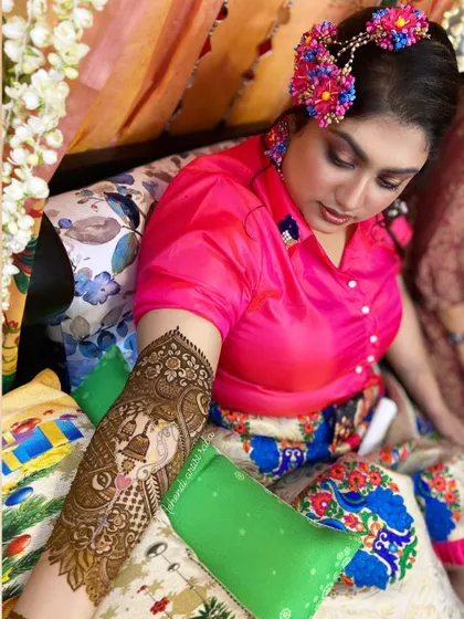 A beautiful shot of a bride with a custom portrait mehendi on her arm. The design depicts a traditional bride in her palanquin (doli).