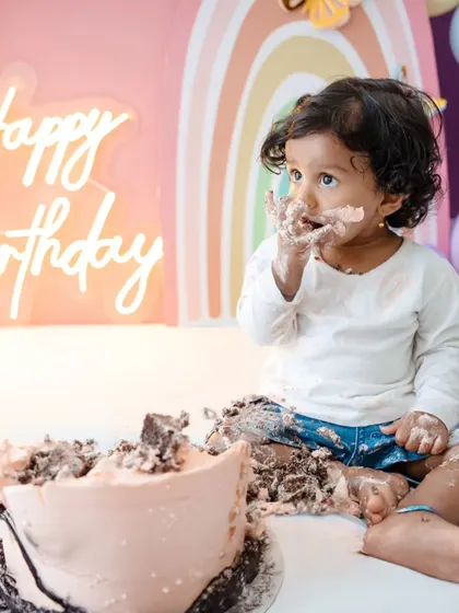 A sweet, messy moment from the rainbow-themed cake smash. I love capturing the joy and wonder of a baby's first birthday.