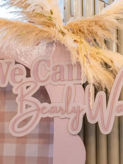 The "We Can Bearly Wait" sign, beautifully crafted and accented with pampas grass, served as the centerpiece of the photo backdrop.