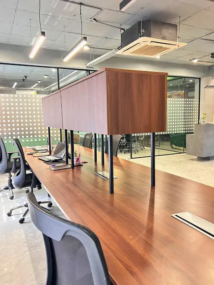 A close-up of the custom workstations, featuring rich wood tones and elevated storage units. The design prioritizes a clean and organized environment to enhance productivity.
