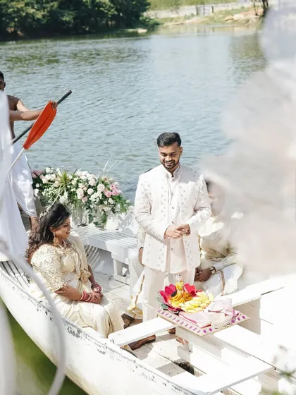 The couple makes a unique entrance on a decorated boat for their lakeside engagement ceremony.