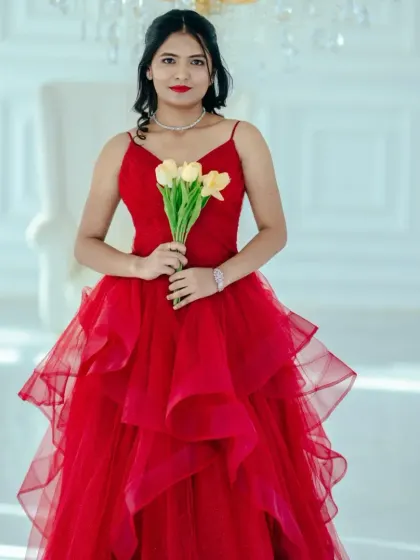 A beautiful portrait of our client in the red tiered ballgown. The soft tulle layers and spaghetti strap bodice create a romantic and feminine look.