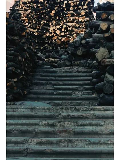 A slightly different perspective of the steps and stacked wood at the cremation ghat. The image confronts the reality of life's end, which in Varanasi is not hidden but is a sacred part of the city's existence.