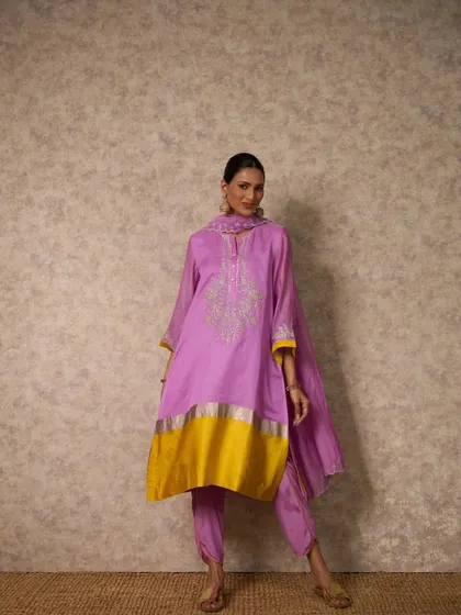 A lovely lilac kurta set with a pop of bright yellow at the hem. This unexpected color combination is fresh and modern, while the silver gota work keeps it festive.