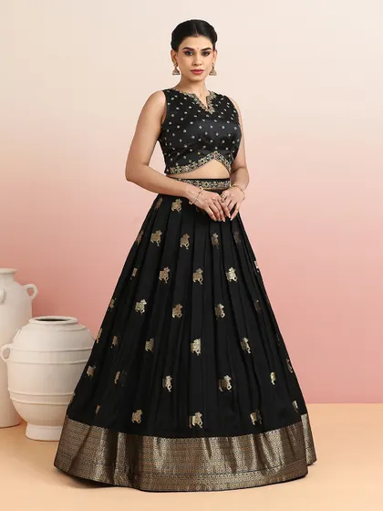 Inspired by the sacred art of Pichwai, this black pleated lehenga features delicate golden motifs of cows. The modern silhouette and traditional artistry make it a unique and sophisticated ensemble for festive nights and wedding receptions.