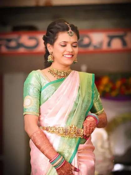 A happy client looking beautiful at a family function. She chose a simple yet elegant temple jewellery set that perfectly complements her silk saree.