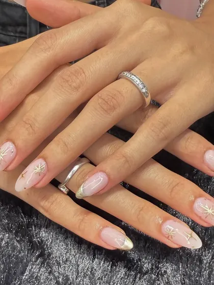 A celestial-inspired design that's both elegant and modern. This set features a sheer, shimmery base with delicate gold French tips and hand-painted gold starbursts.