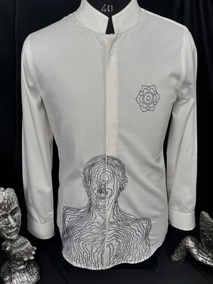 A bold statement in minimalist design. This white shirt features an abstract, linear portrait and a geometric floral motif, both embroidered in black. It is a piece of wearable art, perfect for the modern man.