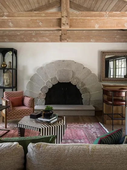 The magnificent stone fireplace is the anchor of this Saratoga living room. We repositioned it to create a more intimate and functional seating area. It’s paired with eclectic furniture, including a striped coffee table and a vintage-inspired rug, to create a warm, layered look.