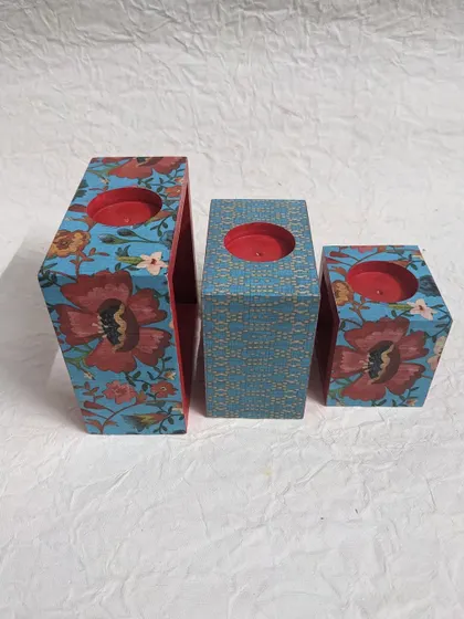 An angled view of the candle holder set, showcasing the different patterns on each block.