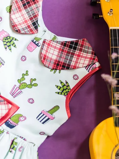 A quirky and fun cactus print dress. The addition of plaid accents on the collar and bow adds an unexpected and stylish twist to this playful design.