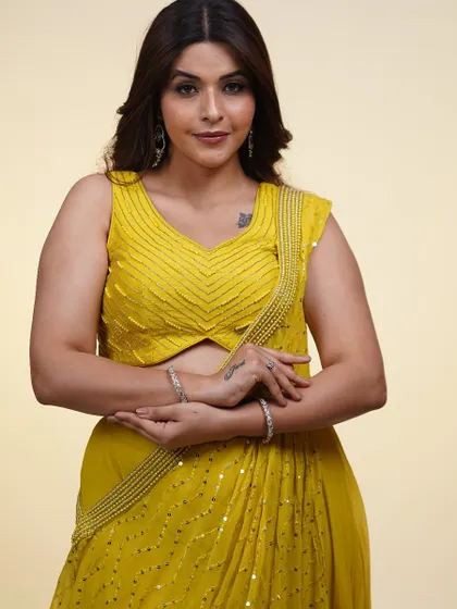 A close-up of this vibrant yellow draped saree. The chevron-patterned beadwork on the blouse adds a modern, geometric touch to this sunny and cheerful outfit.