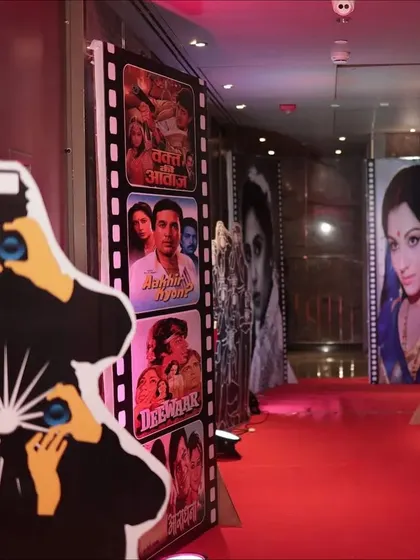 A red carpet entrance lined with classic Bollywood movie posters, instantly transporting guests back to the golden age of cinema.