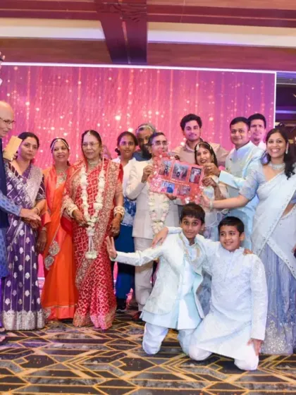 The family presents a gift to the happy couple on stage.
