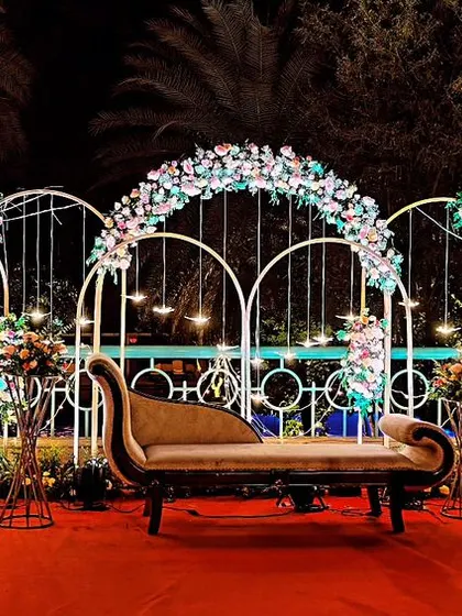 An elegant and coustamised decor for an outdoor engagement party. We used white metal arches adorned with beautiful floral arrangements to create a romantic and picturesque setting.